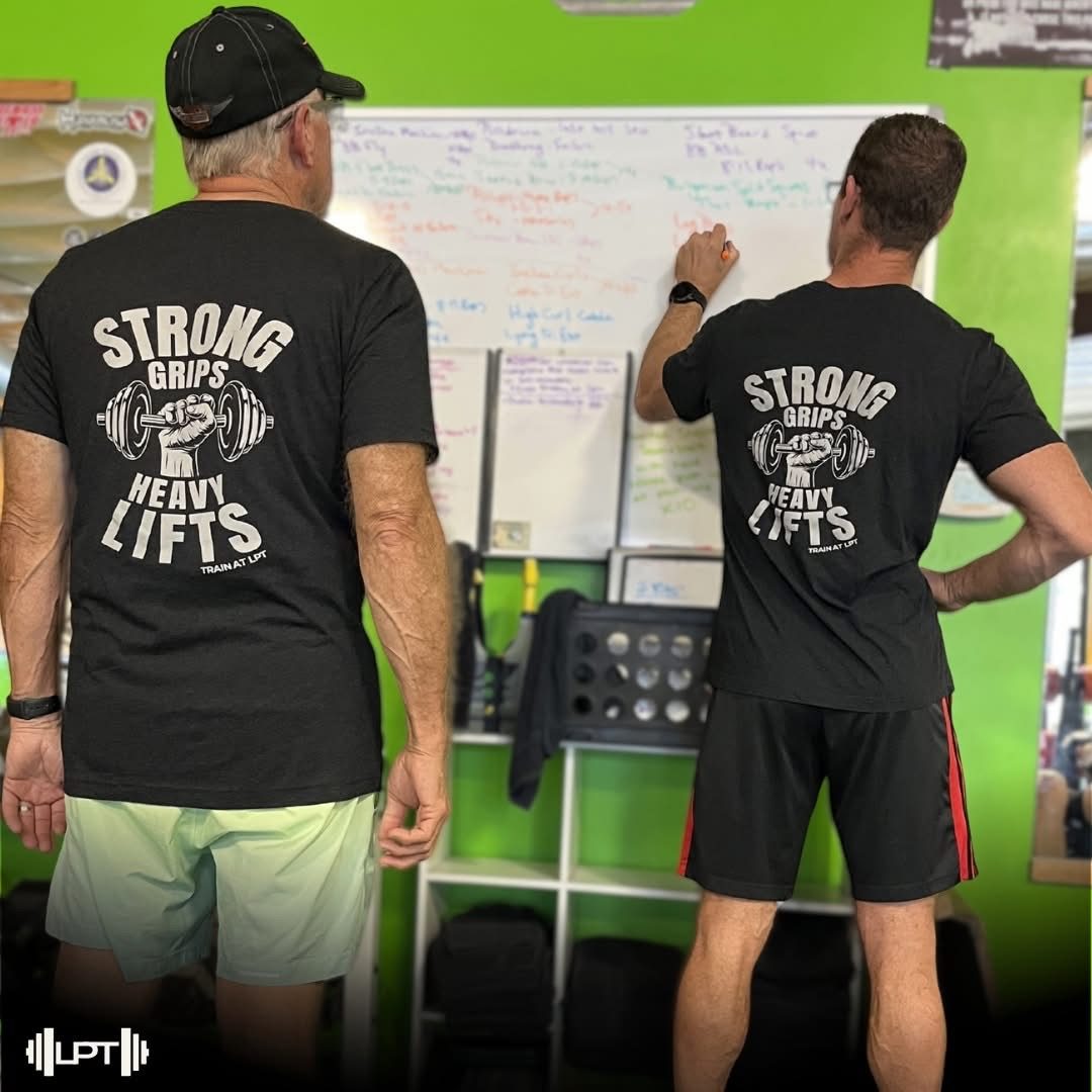 Members viewing programmed workouts on LPT whiteboard